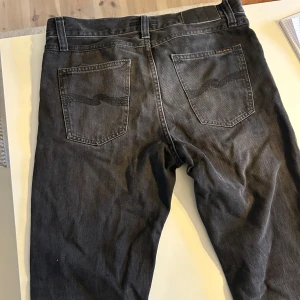 Svarta jeans från Nudie Jeans - Säljer ett par svarta jeans från Nudie Jeans. Jeansen har raka ben och normal passform, med waist 28 längd 30. Modellen är Steady Eddie. Säljer pga jag har växt ur dem för några månader sen. Passar de flesta under 175