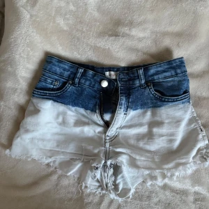 Dip dye jeansshorts med fransig kant - Snygga jeansshorts med dip dye-effekt i blått och vitt. Lågmidjade!