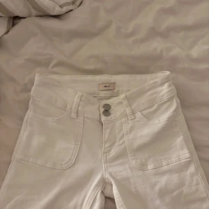 Vita jeansbyxor från Nils - Snygga vita låg midjade jeans ifrån Nelly. Bootcut och använt ett fåtal gånger. Säljer då de är för små. 