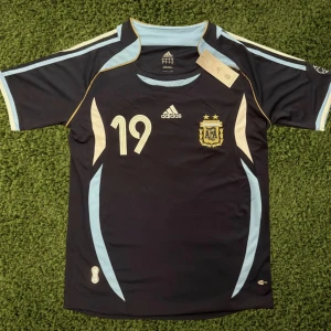 Argentina Messi 19 Adidas fotbollströja - Snygg Argentina fotbollströja från Adidas med Messi och nummer 19 på ryggen. Tröjan är helt ny, är storlek S men kan passa M. Meddela gärna om du är intresserad.