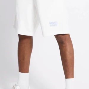 Vita shorts från Music Daily - Snygga vita shorts från Music Daily med avslappnad passform och diskret logga framtill. Perfekta för varma dagar, tillverkade i mjukt bomullsmaterial som känns skönt mot huden. Klassisk design med raka ben och elastisk midja.