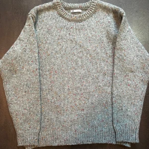Speckle Knit Sweater – Zara - Stickad tröja i ljusblå ton med färgstänk i garnet som ger ett livfullt men nedtonat intryck. Från Zara, i storlek M. Mjuk, varm och lätt att styla – perfekt för lager på lager eller som den är.
