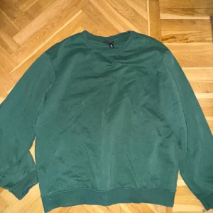 Grön sweatshirt i bomull - Enkel och stilren grön sweatshirt med rund hals och långa ärmar. Tröjan har en relaxed passform och är tillverkad i mjuk bomull, perfekt för chill dagar eller när du vill ha en clean look.