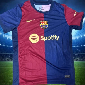 FC Barcelona matchtröja Nike blå/vinröd - Snygg FC Barcelona fotbollströja från Nike med klassisk halva-halva design i blått och vinrött. Tröjan har klubbmärke, Nike-logga och Spotify som sponsor framtill. Korta ärmar och lätt, ventilerande material perfekt för match eller träning. Storlek S,M