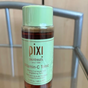Pixi Vitamin-C Tonic toner 100 ml - Fräsch ansiktstoner från Pixi med Vitamin C och ferulinsyra som ger glow och jämnar ut hudtonen. Kommer i en genomskinlig plastflaska med mintgrönt lock och etikett. Perfekt för dig som vill boosta huden med antioxidanter och lyster.
