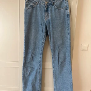 Ljusblå raka jeans - Säljer ett par klassiska ljusblå jeans med rak passform och normal midja. Jeansen har fem fickor, dragkedja och knapp framtill. Perfekta till vardags och lätta att matcha med olika stilar. Materialet är 100% bomull för en skön känsla.