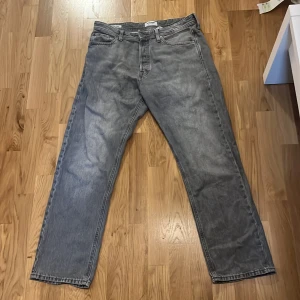 Grå relaxed jeans från Jack & Jones - Storlek: W30 L32 (motsvarar ca midja 76 cm, innerbenslängd 81 cm) Passform: Relaxed fit – Chris-modell Färg: Grå Legat i garderoben ett tag. Använt ett fåtal gånger, fick de i julklapp för nåt år sedan men de passar inte min stil.