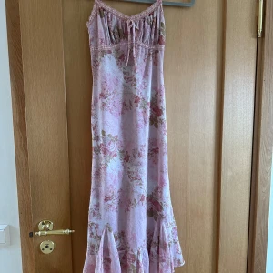 Rosa blommig klänning🩷🌸 - Superfin rosa blommig klänning jag köpte på Urban Outfitters i London. Aldrig använd! Den är tight med volanger längst ner💕💕 Den ser typ blå ut på första bilden? Men det är bara ljuset, den är mer som på andra bilden🙂‍↕️