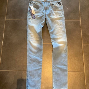Replay Anbass Hyperflex HELT NYA!! - Säljer ett par helt nya Replay Anbass Hyperflex jeans i storlek 32/36 men sitter som 30/34, måtten är 110cm i byxben, och 37cm i midja. Dessa ljusblå jeans med slitningar är både stilrena och otroligt bekväma tack vare Hyperflex-teknologin. Perfekta för en avslappnad men trendig look! Hör av dig vid funderingar eller intresse! Tar gärna fler foton om det önskas!