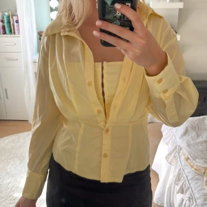 Gul skjorta från Zara i XS - Snygg ljusgul skjorta från Zara i storlek XS. Skjortan har klassisk krage, långa ärmar och knappar framtill. Tillverkad i ett tunt och lätt bomullstyg, perfekt för vår och sommar. Enkel att styla både öppen och stängd.