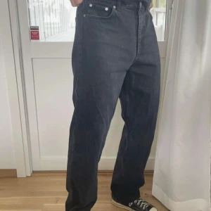 Svarta loose fit jeans från Weekday - Säljer ett par svarta jeans med loose fit och raka ben. Klassisk femficksmodell med hög midja och silverfärgade nitar. Jeansen är i kraftig denim och har en enkel, stilren look som passar till sneakers. Måtten är 29/32❤️ skriv vid intresse 