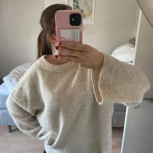 Beige oversized stickad tröja - Supermjuk och oversized stickad tröja i beige med breda ärmar och rund hals. Perfekt för lager-på-lager och chill vibes. Tröjan har en enkel design utan mönster och är riktigt skön att bära under kyliga dagar.