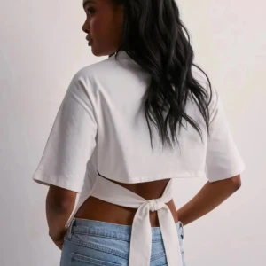 Nelly vit knyt topp - Säljer min vita Nelly T-shirt med knyt i ryggen i storlek XS! Inte använd en ända gång så i princip i nyskick! Skriv om ni vill ha bilder 💖💖