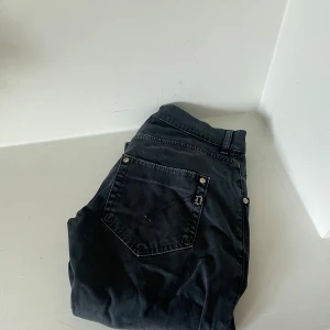 Svarta Dondup jeans - Svarta jeans från Dondup i modellen 'Sam'. De har smal passform och har inga defekter förutom för att självaste ”Sam” lappen hänger lite. Nypris ca. 3000kr mitt pris 499kr bredd 30 längd 30.