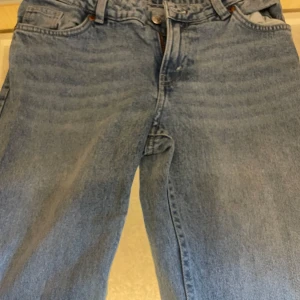 Klassiska blå bootcut jeans - Säljer ett par klassiska blå jeans med rak passform och normal midja. Jeansen har fem fickor, bälteshällor och stängs med knapp och dragkedja. Märket är monki och passar xs/s