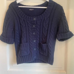 Mörkblå stickad kofta  - Kortärmad mörkblå stickad kofta från Okay. Bra skick