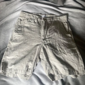 Beige linne-shorts med fickor - Snygga beige shorts från these glory days  i linneblandning. Klassisk modell med bälteshällor, sidofickor och två bakfickor. Perfekta för varma dagar och har en avslappnad passform. Storlek 44 passar ca 170 HELT NYA