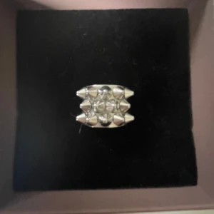Bred silverfärgad ring med nitar - Cool bred ring i silverfärg med flera spetsiga nitar framtill. Ringen är från Edblad i storleken S och är köpt på Edblad för 399kr💕