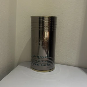 Jean Paul Gaultier Le Male EdT 40ml - Jean Paul Gaultier Le Male Eau de Toilette 40 ml i sin ikoniska silvriga metallburk. Förpackningen har en maskulin design med blå detaljer och en bild av den klassiska torsoflaskan. Perfekt för dig som gillar unika och stilrena parfymer.oöpnad