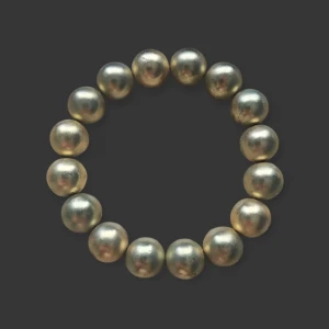 Elastiskt armband med stora pärlor - Coolt armband med stora, runda pärlor i metallic guldfärg. Pärlorna är trädda på en elastisk tråd så det är enkelt att ta på och av. Perfekt accessoar för att ge din outfit lite extra edge. Små defekter längst armbandet (se Bild 3)