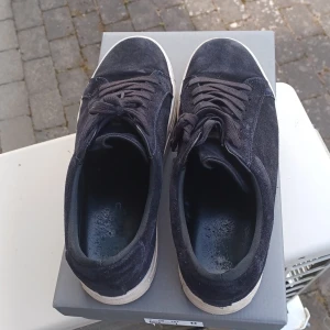 Svarta mockasneakers med svart sula. - Snygga svarta sneakers från Vagabond i mocka med klassisk låg profil och vit platt sula. Skorna har rund tå och snörning framtill för en stilren look. Perfekta för dig som gillar en enkel men trendig stil. Ordinarie pris 1400. Pris kan diskuteras.