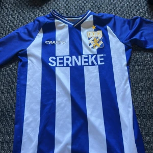 IFK Göteborg matchtröja Craft 158-164 - Säljer en officiell IFK Göteborg fotbollströja från Craft i storlek 158-164. Tröjan har klassiska blå och vita vertikala ränder, klubbmärke på bröstet och sponsortryck. Tillverkad i lätt och ventilerande polyester, perfekt för match eller träning.