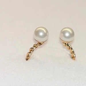 Guldplaterad ring med pärlor - Säljer en ring i guldplatering. Ringen är öppen och dekorerad med två pärlor i ändarna. Perfekt för dig som gillar stilrena och eleganta accessoarer.