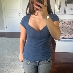 Blå ribbad topp🩵 - Supersnygg blå ribbad topp från Anna Field med v-ringad sweetheart-urringning och korta ärmar. Figurnära passform som framhäver siluetten och ger en modern vibe. Perfekt att styla med jeans eller kjol för en trendig look.🩵 Tröjan är välanvänd men har inga synliga defekter💕