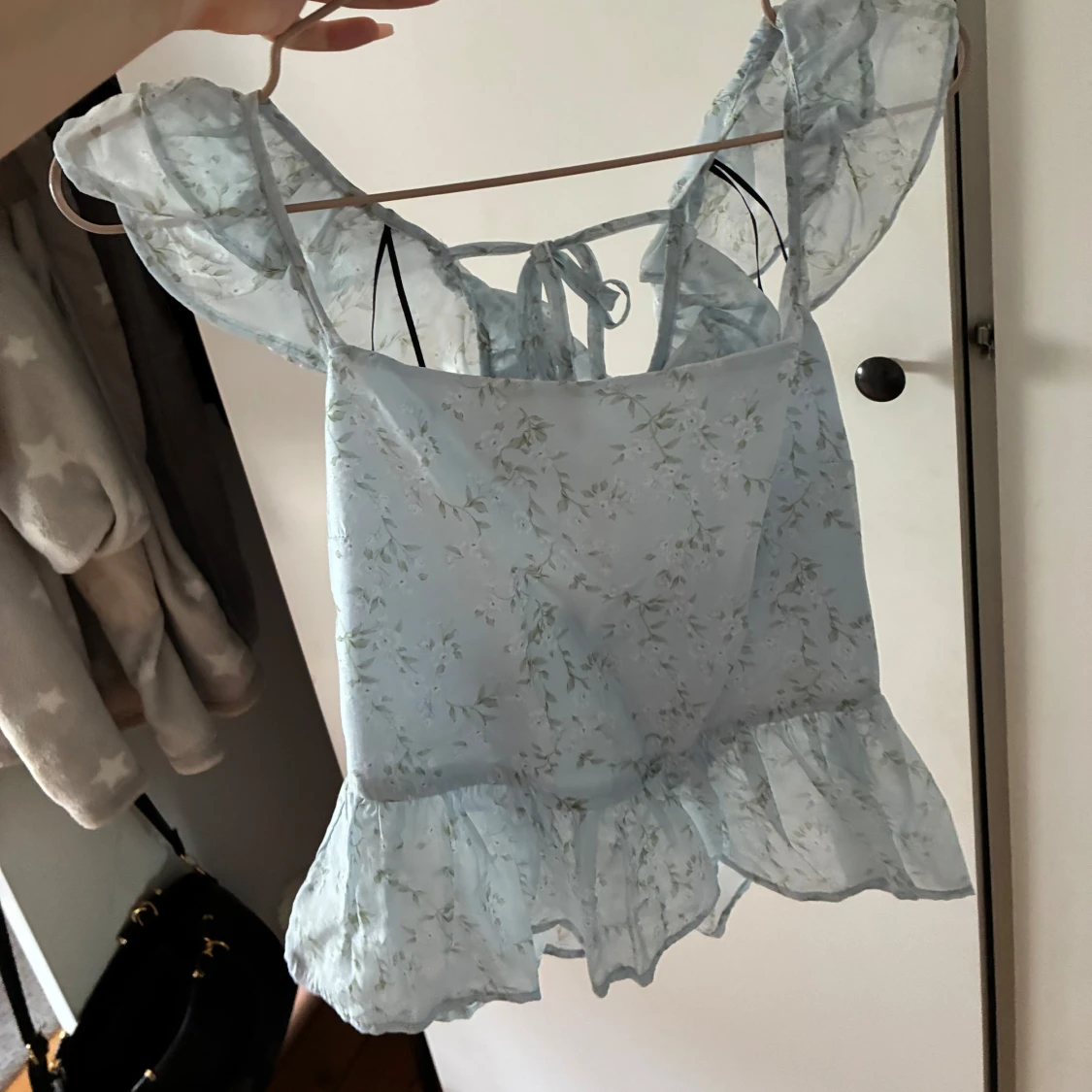 Ljusblå blommig blus med volang