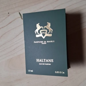 Parfums de Marly Haltane 1,5 ml - Exklusiv parfymprov på 1,5 ml Haltane Eau de Parfum från Parfums de Marly. Kommer i en elegant grön kartong med gulddetaljer. Doften har fräscha och örtiga toppnoter, läder, trä och saffran, samt en modern touch av pralin och oud.