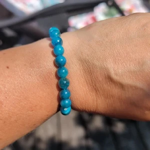 Turkost pärlarmband med stenar - Snyggt armband med runda pärlor i starkt turkosblå färg. Pärlorna är jämnt stora och sitter på en elastisk tråd, vilket gör det enkelt att ta på och av. Perfekt accessoar för att ge din outfit lite extra färg. nytt