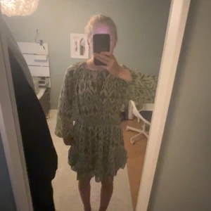 Grönmönstrad kortklänning med volang - Supersöt kortklänning med grönt och beige mönster, från ZARA men som inte säljs längre. Klänningen är lite använd men fortfarande i jättebra skick.💚