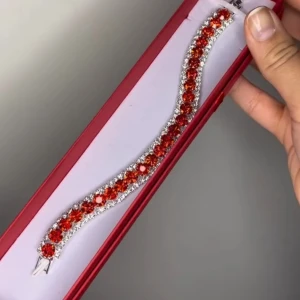 Glittrigt armband med röda stenar - Armband med stora runda röda stenar i mitten och små gnistrande klara stenar runtom. Silverfärgad bas som ger en lyxig känsla. Perfekt för dig som vill sticka ut med färg och bling. Finns i röd, blå och rosa. Ej använda utan kommer från min small business. 