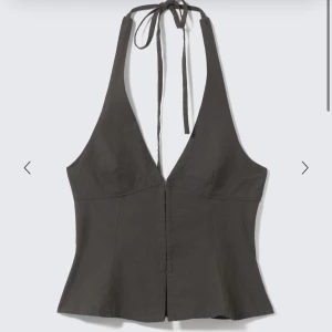 Mörkgrå halterneck korsett från Weekday - Såååå snygg helt oanvänd mörkgrå halterneck top från weekday som knäpper fram och knyter i rosett där bak. Sjukt snygg med jeans och solglasögon om man vill stylea ner den eller mer festlig med typ en minikjol å boots. Endast testad, säljer endast då jag redan har en likadan. Original pris 440