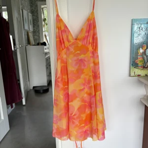Blommig sommarklänning med snörning - Säljer den här jättefina somriga korta klänningen från Zara. Klänningen är helt oanvänd då jag hade tänkt att använda den på min födelsedag, men slutade med att använda nåt annat. Jättefin klänning som framhäver din siluett bra, skriv för frågor❤️🥰