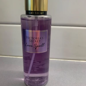 Victoria's Secret Love Spell mist - Fräsch och söt body mist från Victoria's Secret i doften Love Spell. Kommer i en genomskinlig plastflaska med lila vätska och guldig kork. Rymmer 250 ml och har en feminin, fruktig och blommig doftprofil.