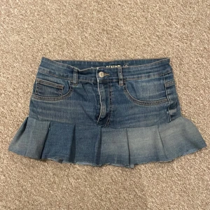 Blå jeanskjol med volangkant - Supersöt kort jeanskjol i blå denim med volangkant nedtill. Vet inte storleken men tror den är typ xs-S midjemåttet är ungefär 78 cm