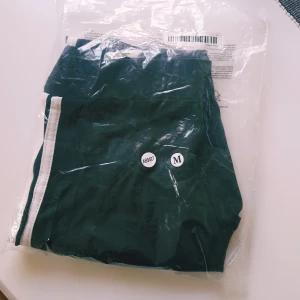 Svarta leggings med vita ränder från temu strl M - Svarta leggings med vita ränder längs sidorna. Tight passform och hög midja, perfekta för träning eller chill. Tillverkade i ett stretchigt syntetmaterial som sitter skönt hela dagen.  Nya så inget att anmärka på
