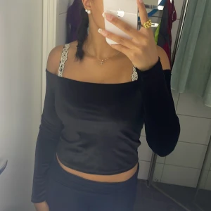 Svart sammetstopp offshoulder FB Sister - Säljer en svart, croppad offshoulder topp från FB Sister i mjuk sammet. Toppen har långa ärmar och sitter tight mot kroppen. Perfekt för dig som gillar en stilren och trendig look med lite extra edge. Kan ha den båda vardagligt och till speciella tillfällen! Säljer efter att den är för stor. 