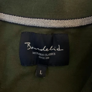 Olivgrön pikétröja från Bondelid - Snygg olivgrön pikétröja från Bondelid, perfekt för en clean och stilren look. Vid mista lilla hör av er!🔥