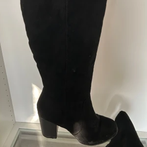 Höga svarta boots - Svarta boots med klack och liten dragkedja. Mocka-liknande material