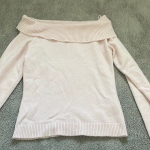 Ljusrosa offshoulder stickad tröja Gina Tricot - Supersöt ljusrosa stickad tröja från Gina Tricot med bred ribbad kant och offshoulder-modell. Perfekt för dig som gillar en feminin och trendig look. Långärmad och mjuk, passar till både jeans och kjol.