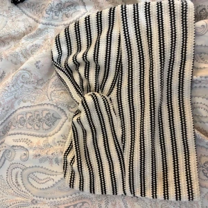 Randig stickad topp - Superfin stickad topp med svartvita ränder. Toppen har en rak passform och är perfekt för dig som gillar en enkel men ändå cool stil. Materialet är mjukt och stretchigt, vilket gör den bekväm att bära hela dagen. Köpt i Spanien, nästan aldrig använd.