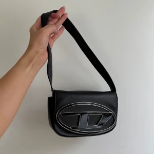 DIESEL 1DR SHOULDER BAG BLACK - DIESEL 1DR SHOULDER BAG BLACK 🤍 Säljer min älskade väska eftersom den inte kommer till användning. Så nu ska den få en ny ägare!    Nyskick!!! ✨⭐️   Silverdetaljer och magnetförslutning. Nypris 4500kr. Önskas snabb affär ✨ skriv för bud