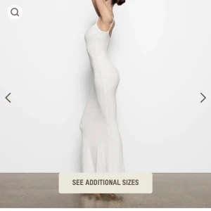 Vit Skims långklänning med smala axelband - Supersnygg vit långklänning med smala axelband och figurnära passform. Klänningen har en enkel och stilren design med rak halsringning och ärmlös siluett. Perfekt för dig som gillar minimalistisk och elegant stil. Storlek XS