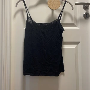 Svart spetslinne - Svart linne med spets i storlek S. Tunt tyg med smala axelband och v-ringning. Stryker innan jag skickar❤️från lager 157