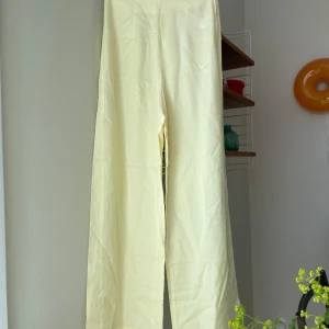 Vida byxor  - Vida byxor i ljusgult av märket Edited. 100 % lycoell. Midjemått: 68 cm. Fint skick! 