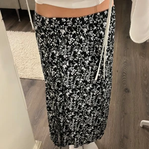Söt Svart blommig kjol - Superfin svart blommig kjol som är i mycket bra skick och använts bara en gång! Kjolen har även fickor vilket är mycket användbart och en liten slits på ena sidan :)