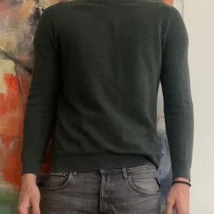 Mörkgrön stickad tröja These Glory Days - Säljer en stilren mörkgrön stickad tröja från These Glory Days. Tröjan har rund halsringning, ribbade muddar och är långärmad. Perfekt för lager-på-lager och funkar året runt. Enkel att matcha med jeans eller chinos.