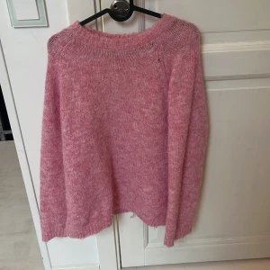 Rosa stickad tröja  - Mysig rosa stickad tröja från Noisy May med rund halsringning och lång ärm. Tröjan har en loose fit och är perfekt för dig som gillar en chill och avslappnad stil. Superenkel att matcha med jeans eller kjol för en trendig look.